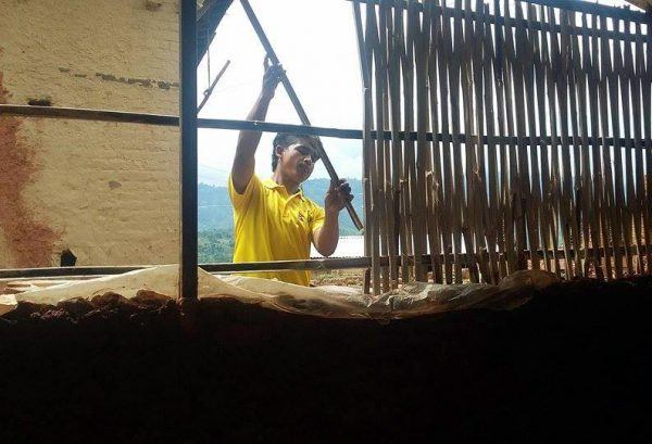 Mies rakentaa taloa Nepalissa maanjäristyksen jälkeen